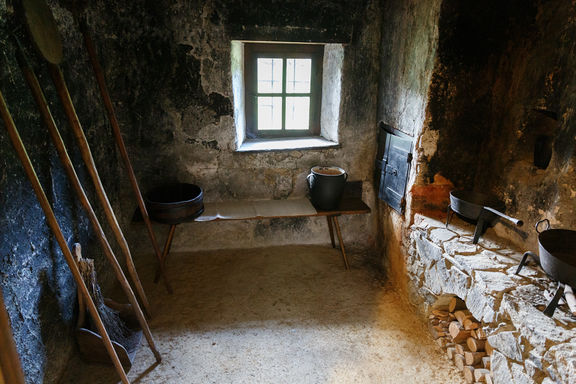 Black kitchen inside Prežihov Voranc Cottage in Kotlje, 2019.