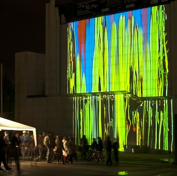 Gravitational painting on the facade of Cankarjev dom, Cultural and Congress Centre by Portugese/Belgian duet Ocubo, Lighting Guerrilla Festival, 2012