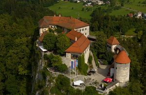 Aerial view of <!--LINK'" 0:34--> showing the layout of castle buildings around the upper and lower courtyards, connected with a staircase. The oldest part of the castle is the Romanesque entrance tower, other sections are Gothic and Renaissance styles.