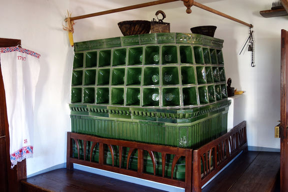 Typical Slovenian tiled stove for heating in Birthplace of France Prešeren with benches around it for sitting on, often the central area of the house, 2013