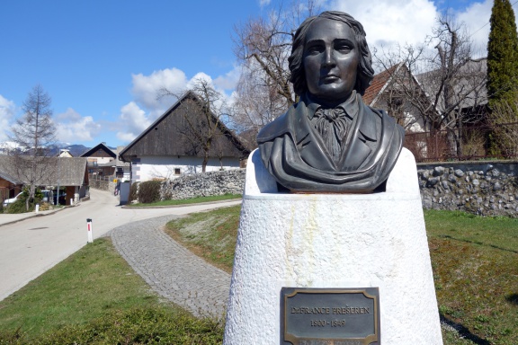 France Prešeren bust in Vrba, the Birthplace of France Prešerenin the background. A bronze replica of a plaster statue created in 1865 by Franc Ksaver Zajec, 2013